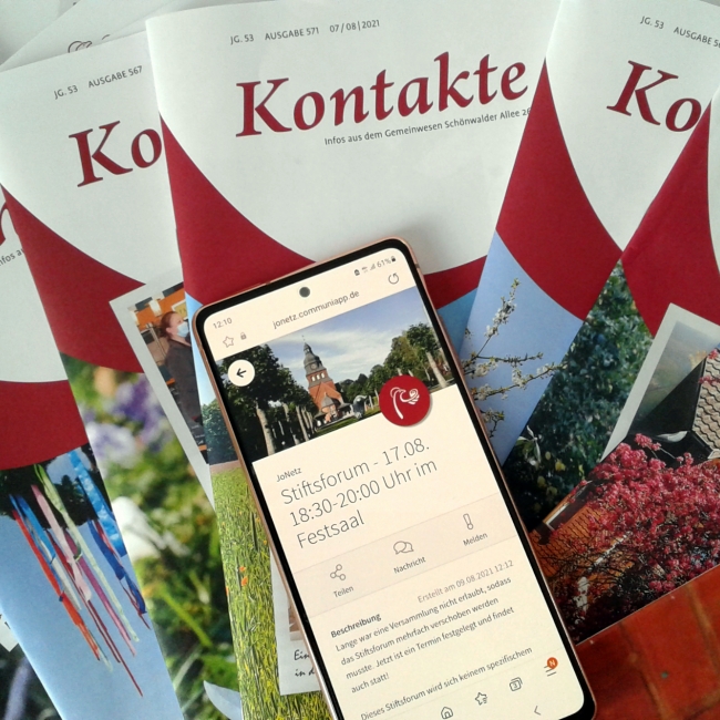Mehrere Magazine der „Kontakte“ liegen übereinander. Oben auf den Magazinen liegt ein Smartphone mit der geöffneten JoNetz-App.