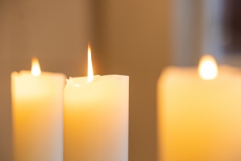 Drei gelbe Kerzen, die leuchten.