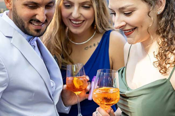 Partygäste schauen gemeinsam auf ein Smartphone