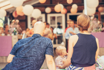 Familie sitzt auf einer Decke während und genießt ein Event