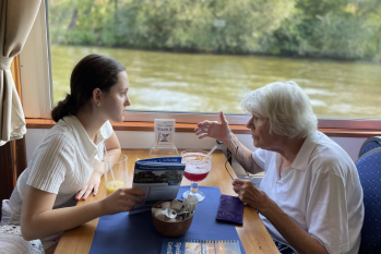 Eine junge und eine alte Dame sitzen sich gegenüber