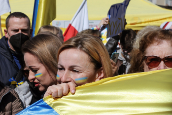 Mehrere Menschen mit einer Flagge der Ukraine.